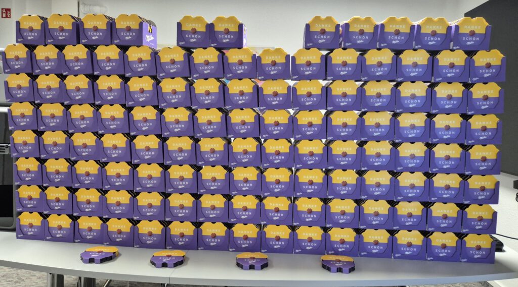 Wand aus 700 Milka-Dankespralinen als Dankesgeschenk-Aktion von Uplink-Pharma für die Mitarbeitenden des Kreiskrankenhauses Weilburg.