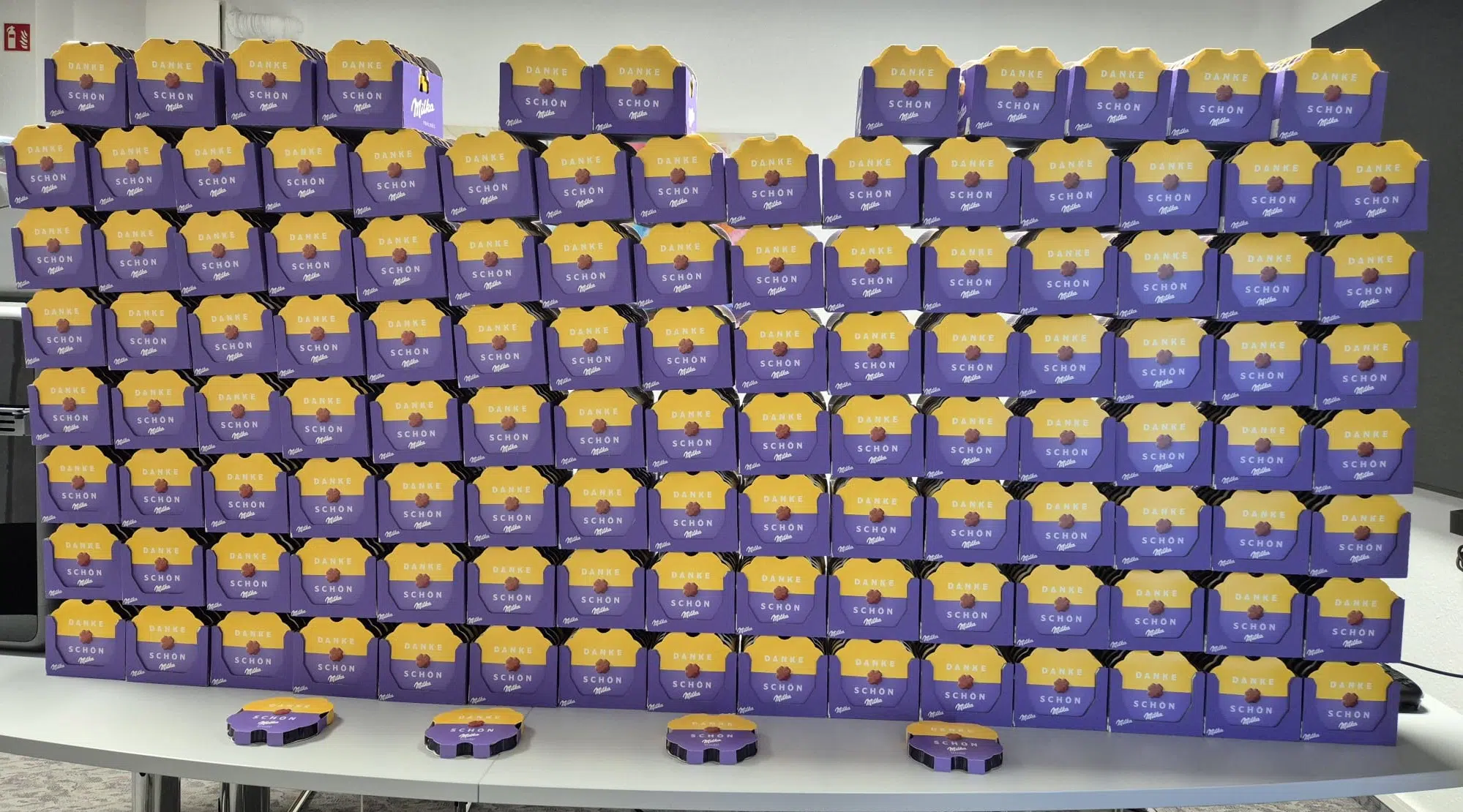 Wand aus 700 Milka-Dankespralinen als Dankesgeschenk-Aktion von Uplink-Pharma für die Mitarbeitenden des Kreiskrankenhauses Weilburg.