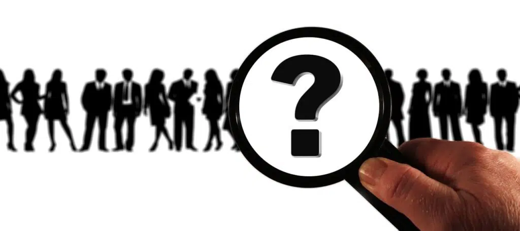 Eine Lupe über gezeichneten Figuren soll eine Zielgruppenanalyse darstellen.